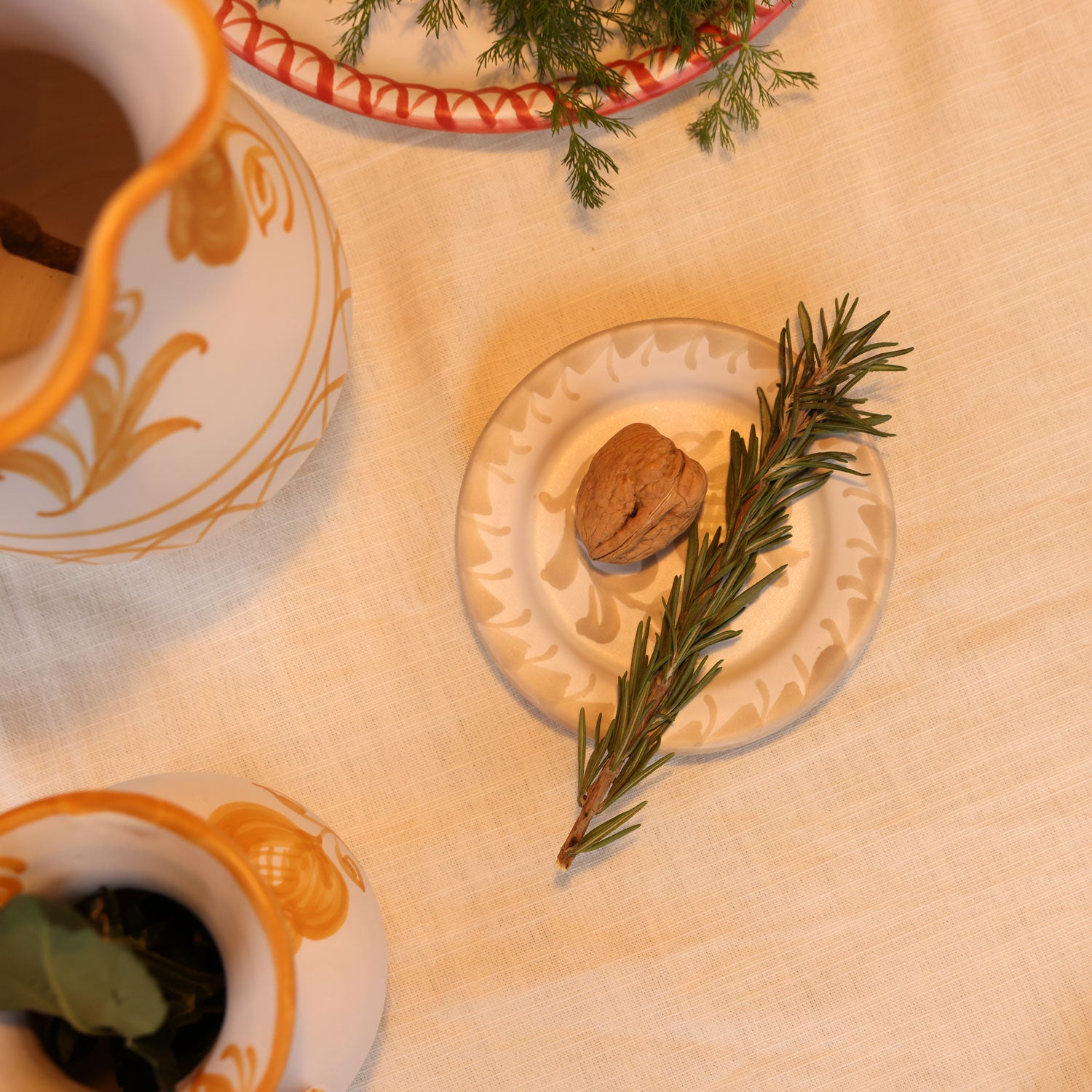 Teacup with saucer, rosemary sprig, and walnut on a wooden surface - lifestyle