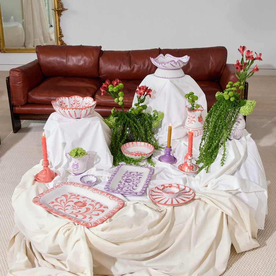 Living room with a table covered in white cloth, granada collection ceramic items, and a brown sofa.
