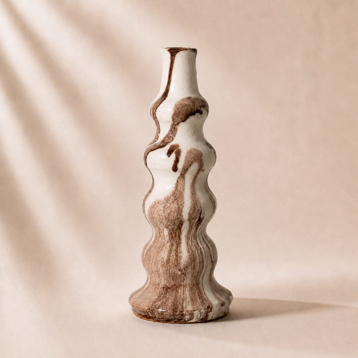 Ceramic vase with wavy design on a beige background
