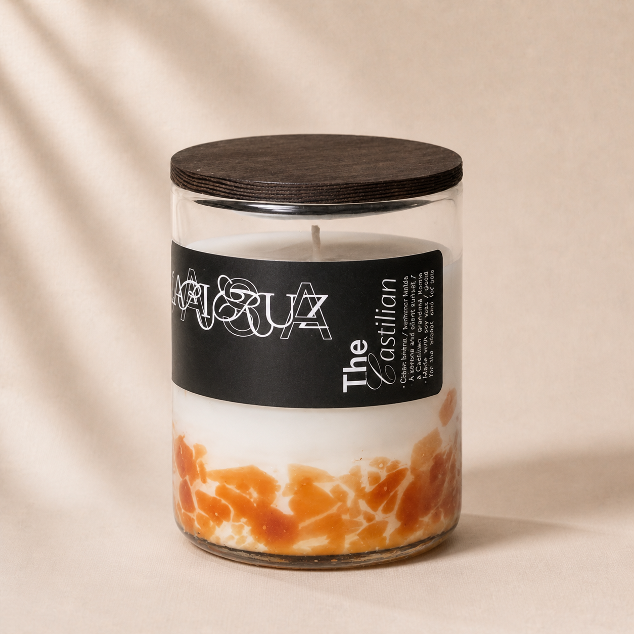 Candle in a glass jar with a black lid and label on a beige background