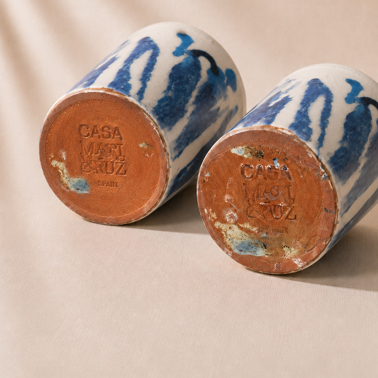 Two ceramic jars with blue and white patterns and 'Casa Mari Cruz' branding on a beige background.