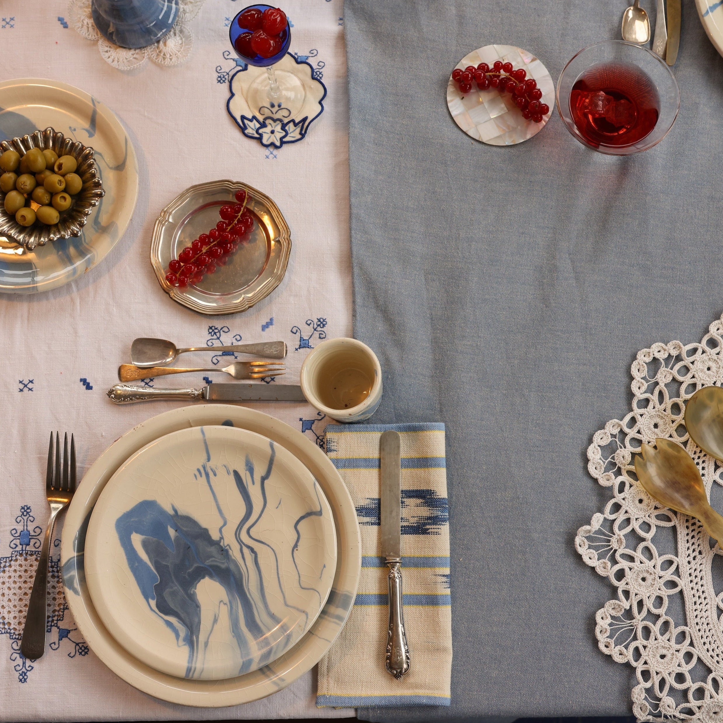 Elegant table setting with plates, cutlery, and glasses on a gray tablecloth.