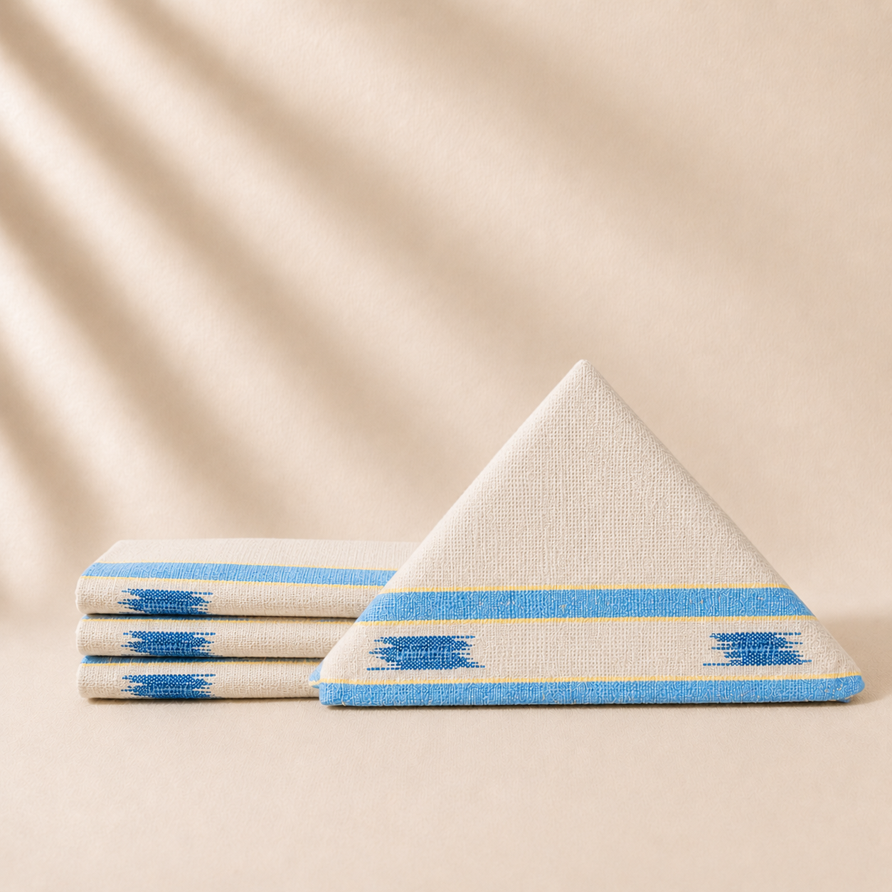 Four coctaik napkins with blue and white patterns on a beige background
