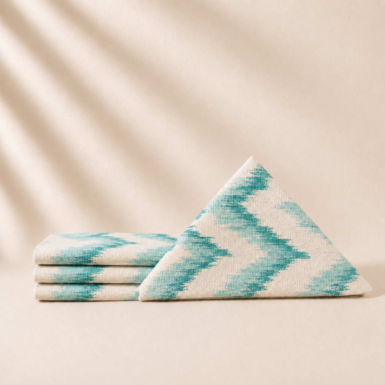 Four turquoise napkins on a beige background