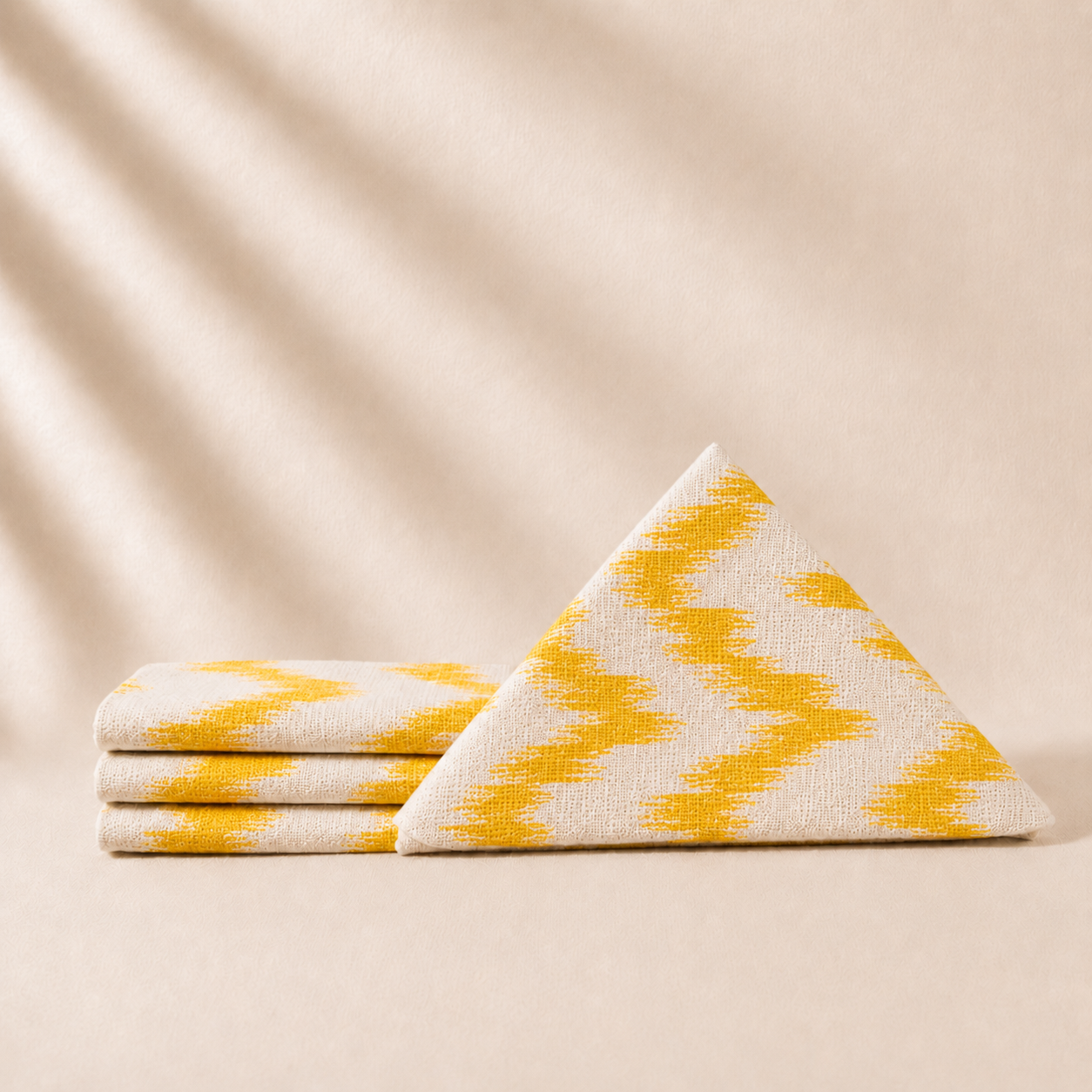 Yellow and white patterned napkins stacked on a beige background