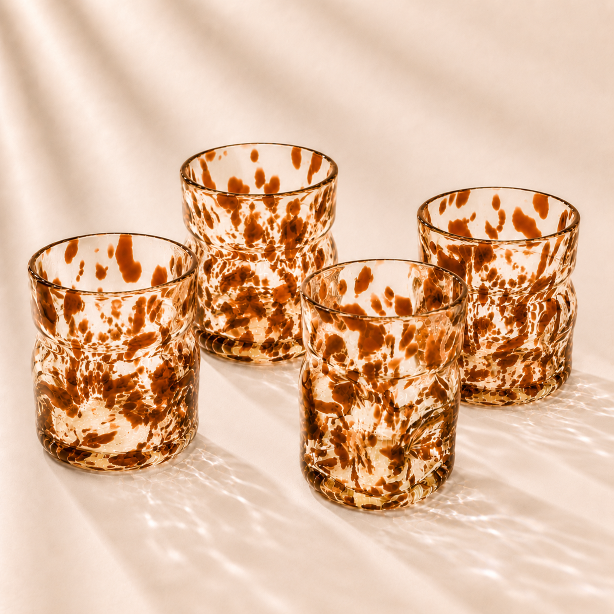Four deflated glasses  on a beige surface