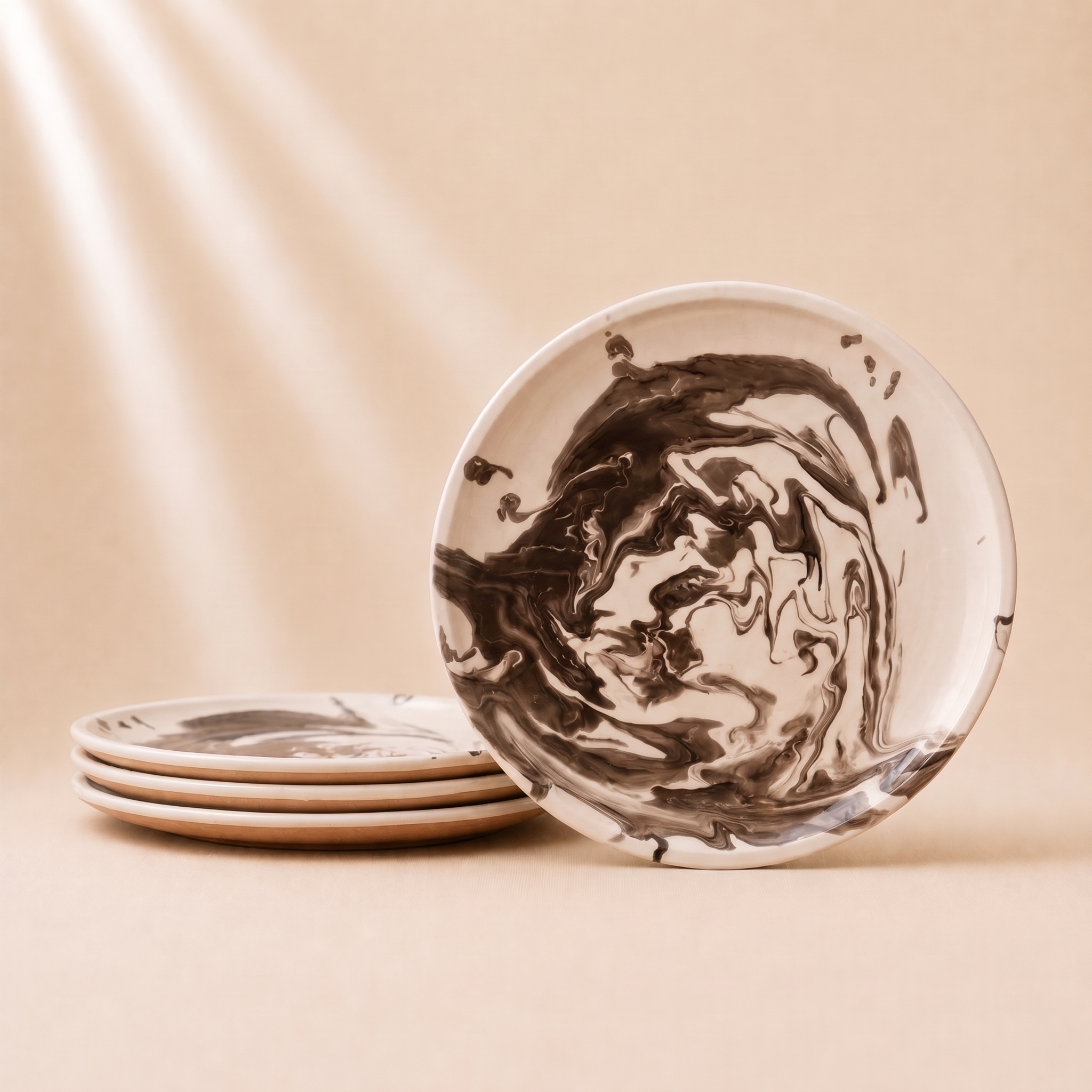 A stack of round ceramic plates with a dark brown and cream marble swirl pattern, with one plate standing upright in the foreground on a warm beige background.