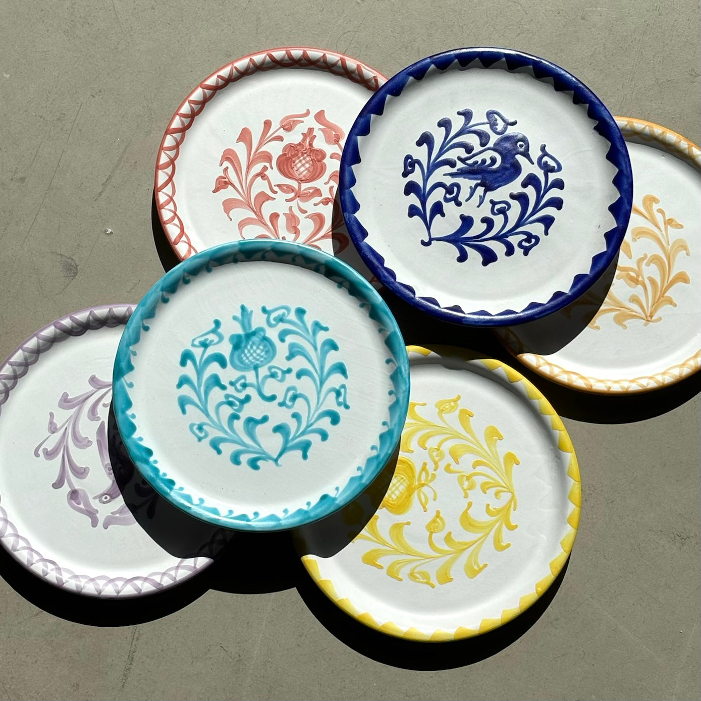 Set of decorative ceramic plates with intricate patterns on a gray surface