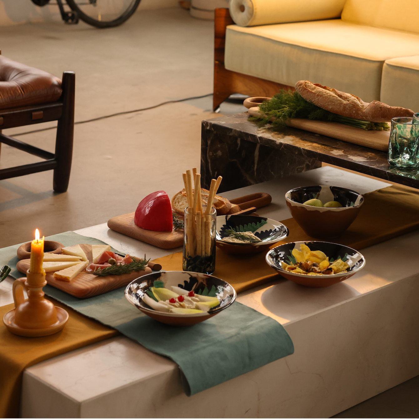 Dining table with appetizers and a candle in a cozy indoor setting