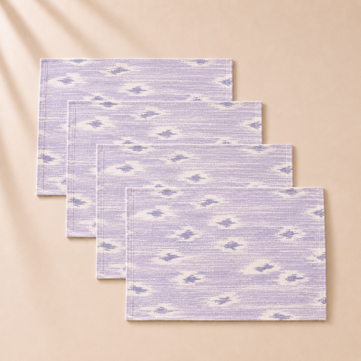 Set of four purple and white patterned placemats on a beige background