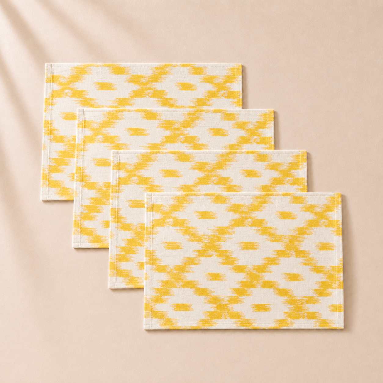 Set of three yellow and white patterned placemats on a beige background