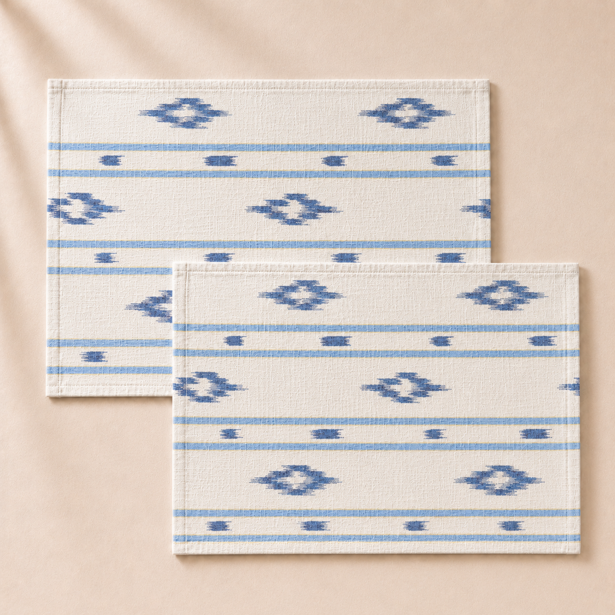 Two white placemats with blue geometric patterns on a beige background