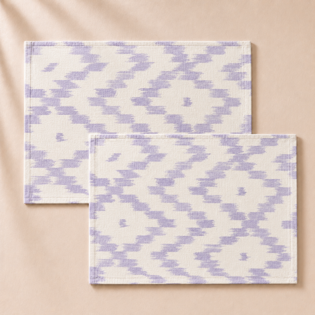 Two purple and white patterned placemats on a beige background