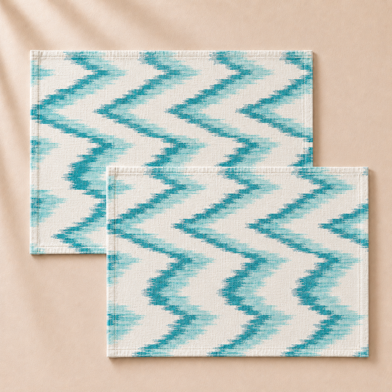 Two turquoise and white zigzag patterned placemats on a beige background
