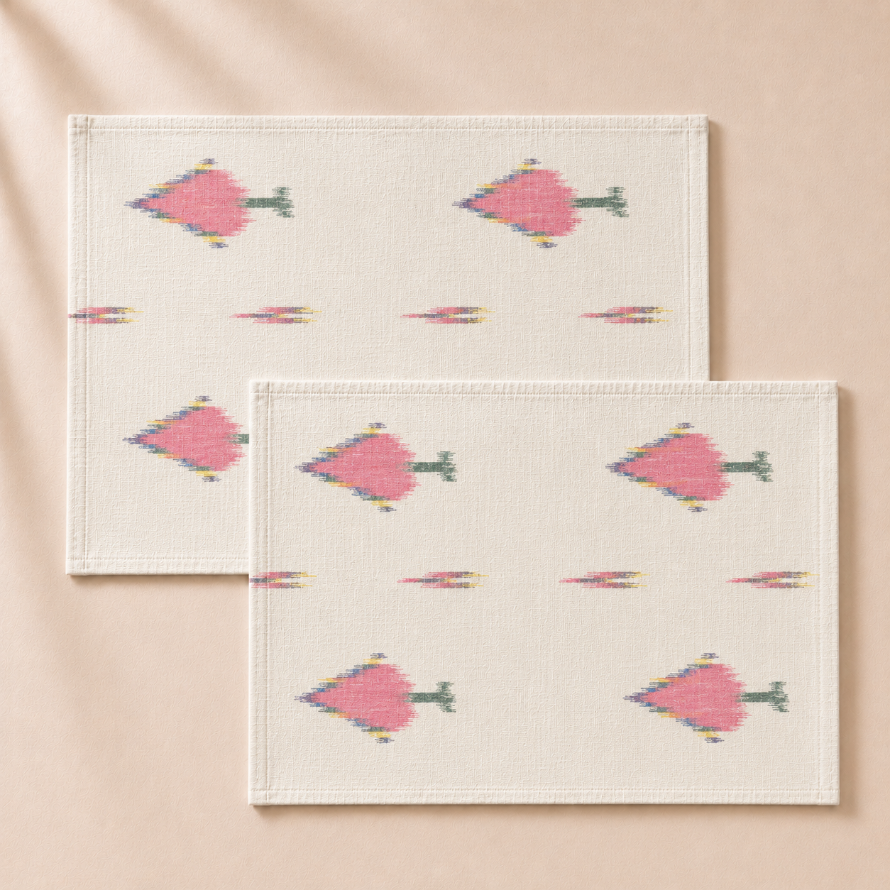 Two white placemats with pink geometric fish pattern on a beige background