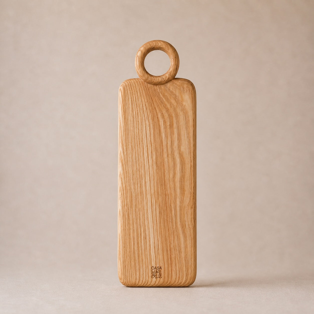 Wooden cutting board with round handle on a beige background