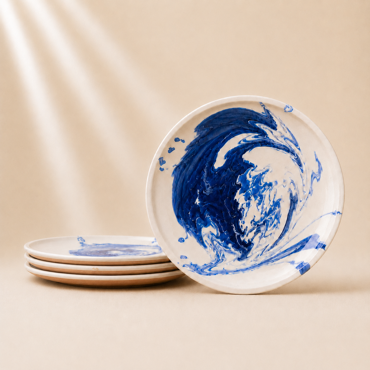 Set of ceramic plates with blue and white marbled design on a beige background