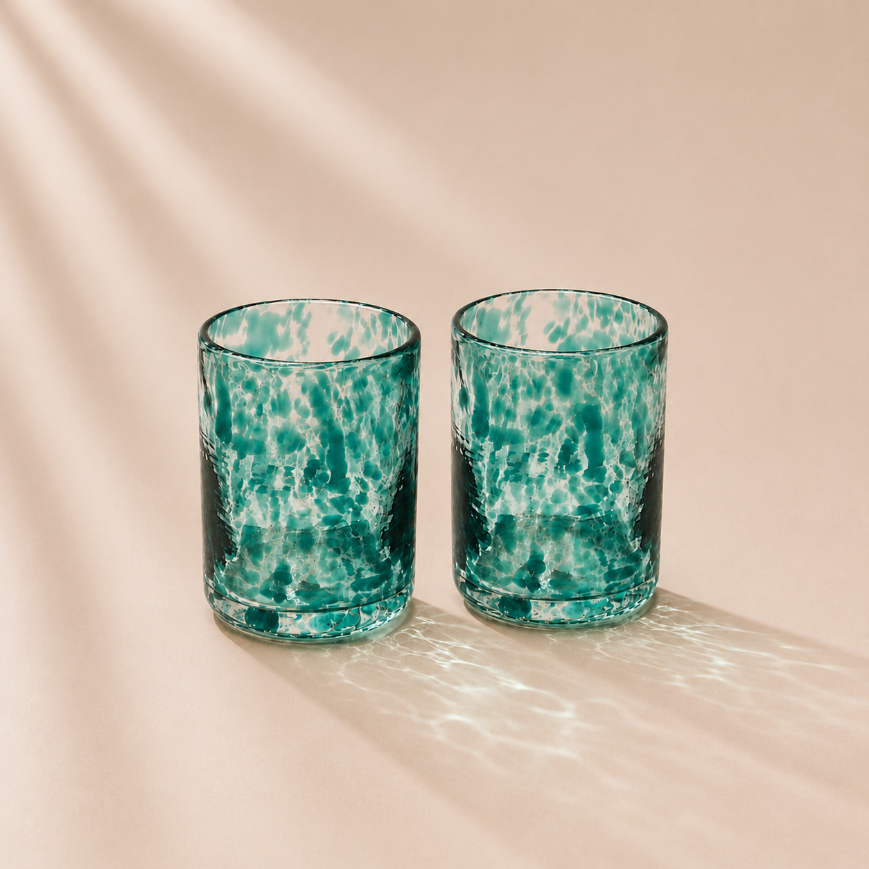 Two spotted glasses  on a beige background