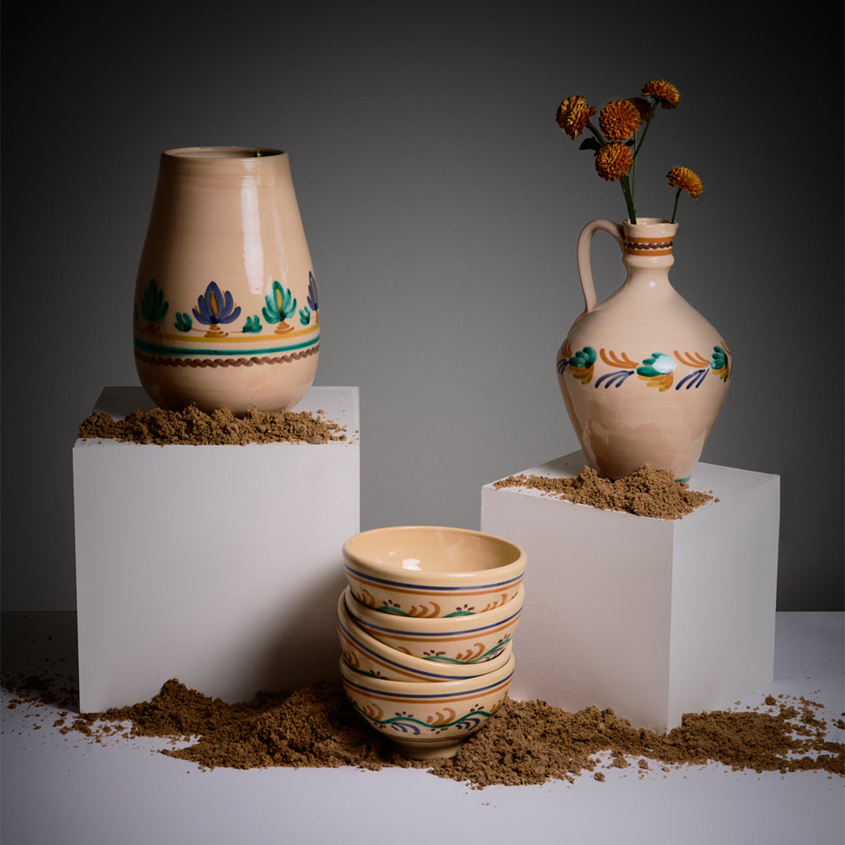 Set of ceramic vases and bowls with decorative patterns on a dark background