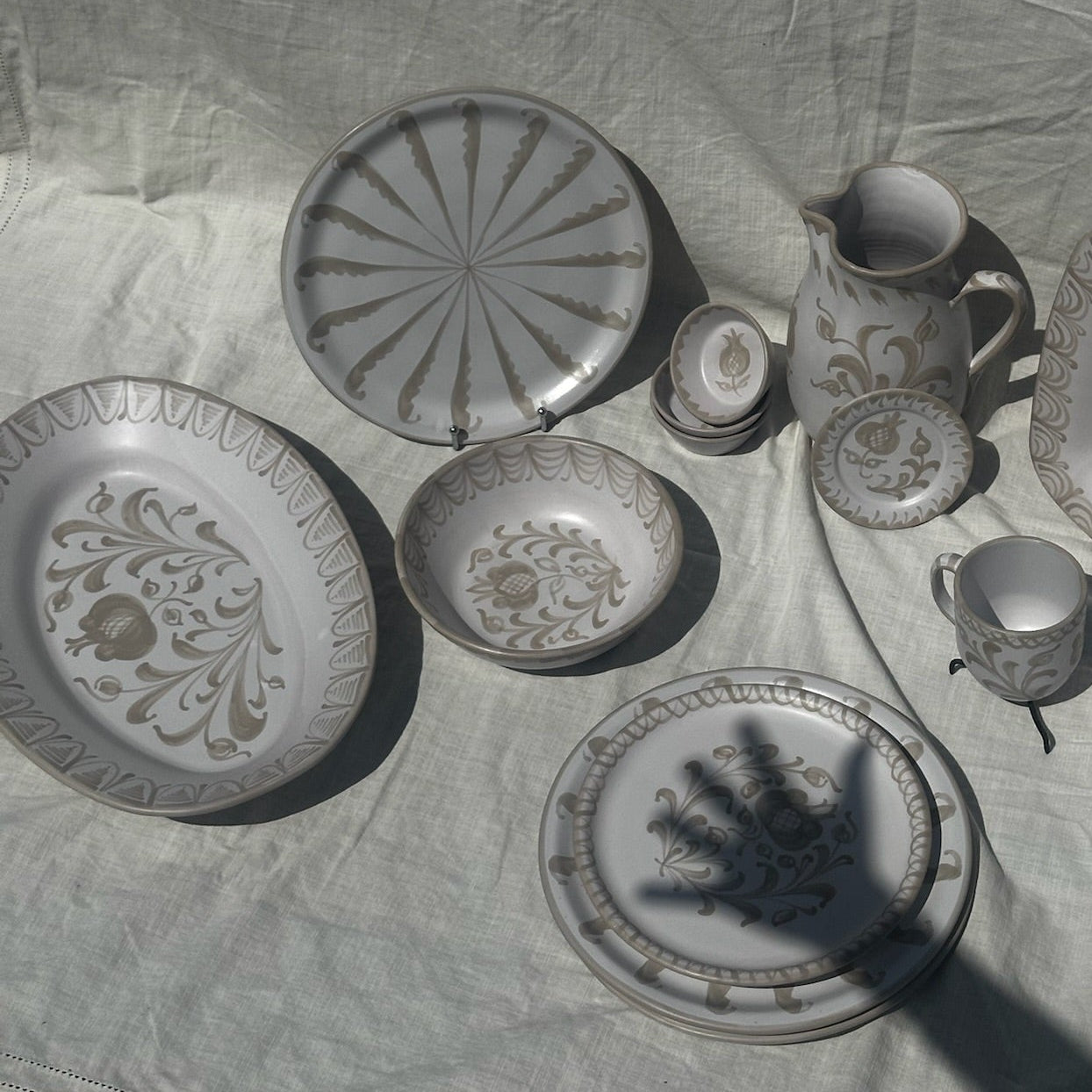 Set of ceramic plates and cups on a textured fabric surface - lifestyle