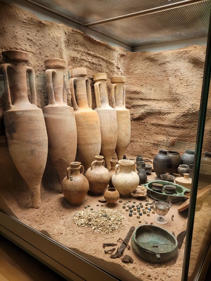 Collection of ancient pottery and artifacts displayed in a museum setting.