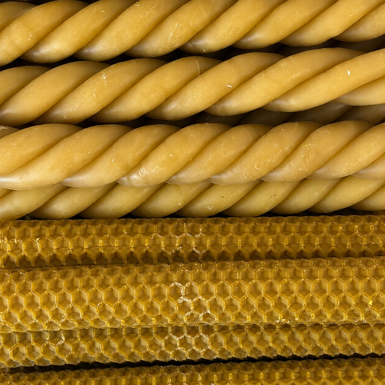 Close-up of twisted honeycomb bars stacked horizontally, showing a golden yellow wax texture with hexagonal cells. - lifestyle