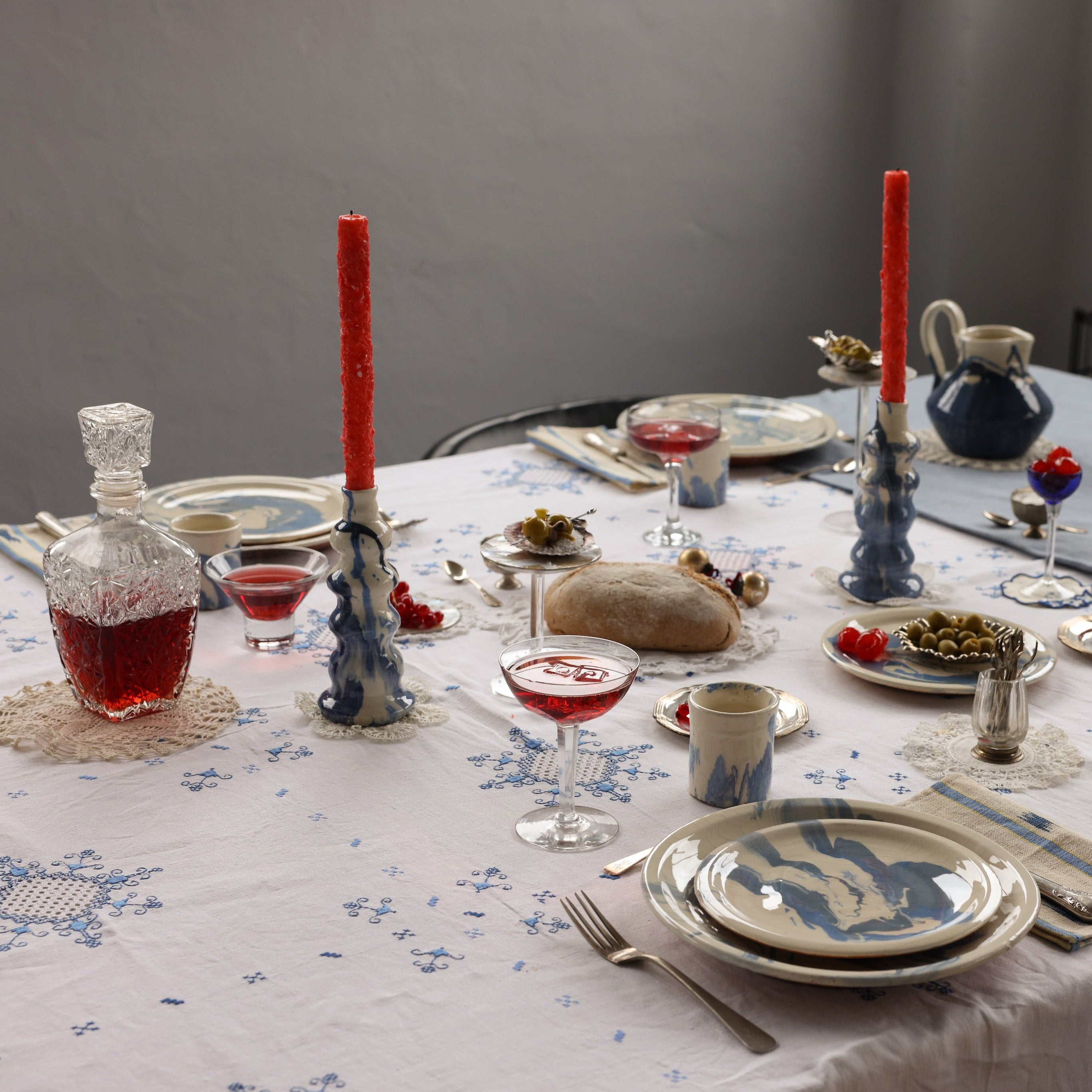 Dining table set for a meal with plates, glasses, and cutlery on a floral tablecloth.  - lifestyle