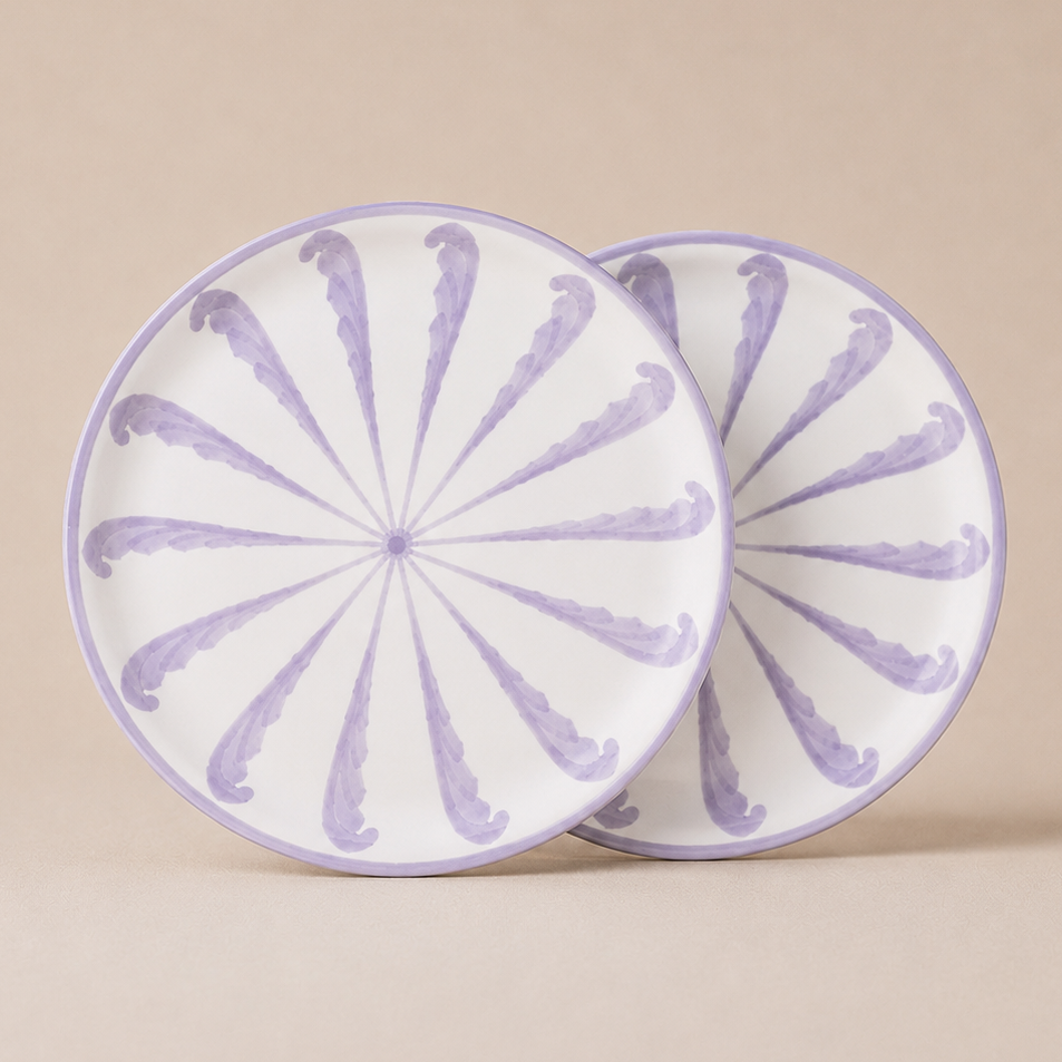 Two round ceramic plates with purple floral patterns on a beige background