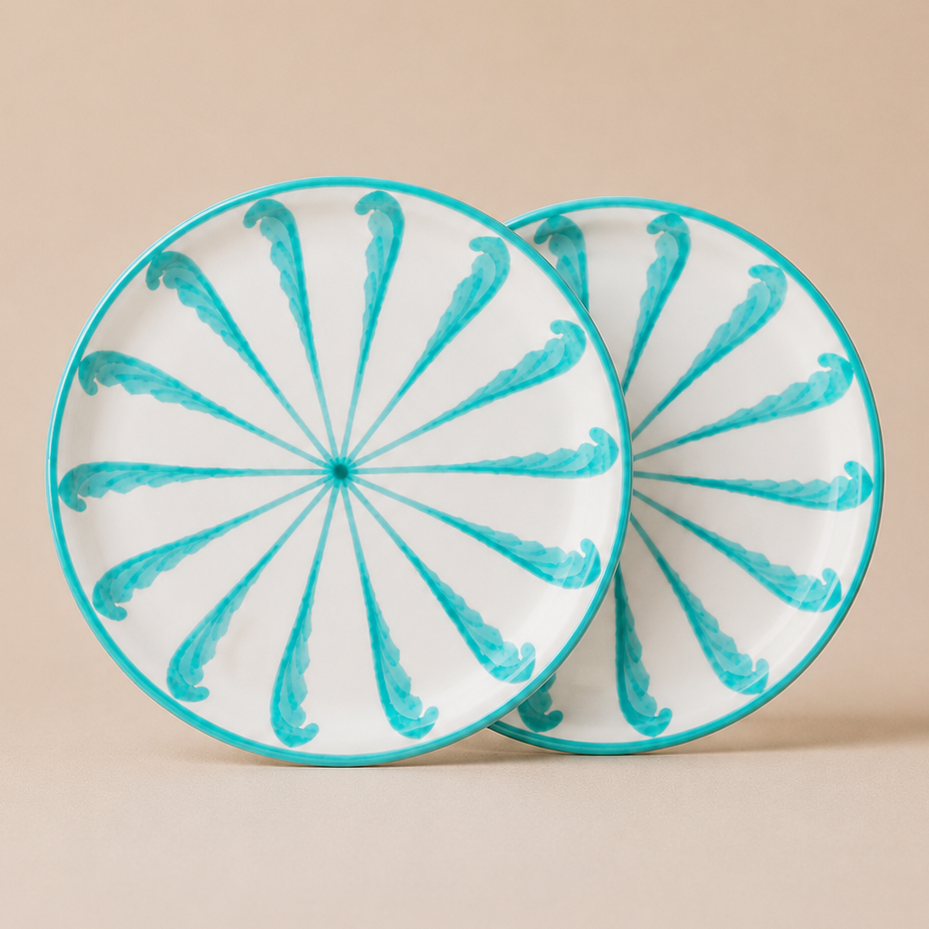 Two ceramic plates with turquoise spiral patterns on a beige background