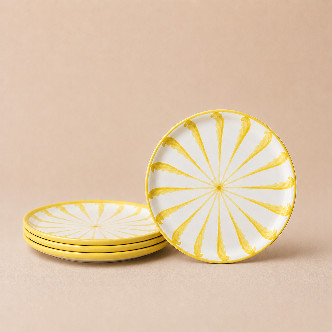 Set of ceramic plates with yellow decorative patterns on a beige background