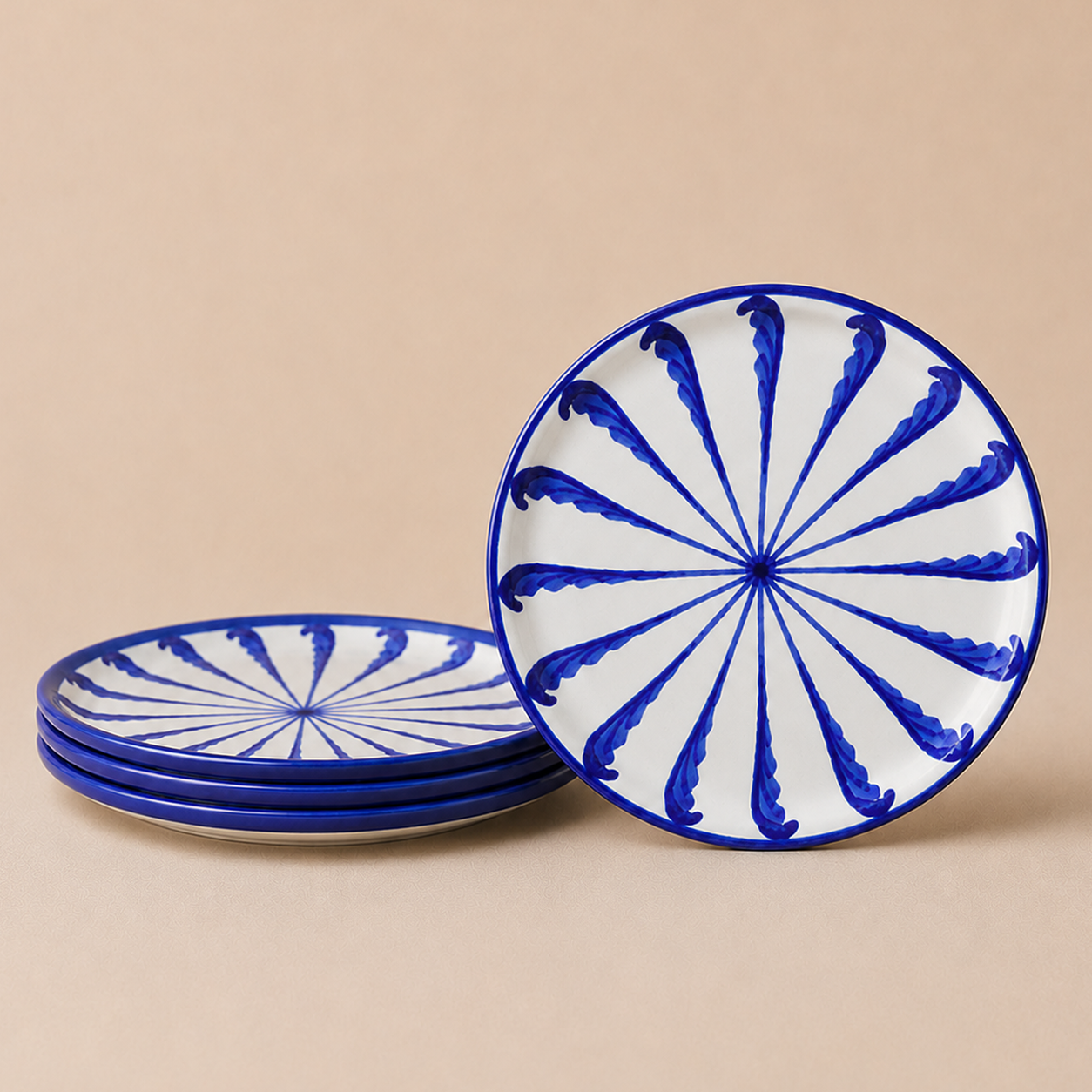 Set of blue and white ceramic plates with decorative patterns on a beige background