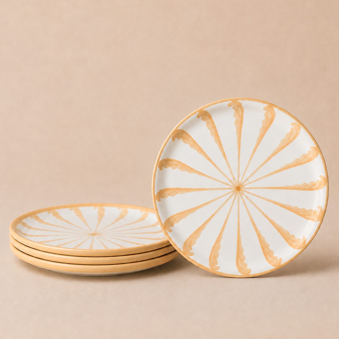 Set of ceramic plates with gold spiral design on a beige background