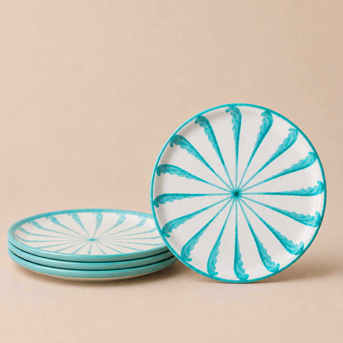 Set of ceramic plates with turquoise and white spiral design on a beige background