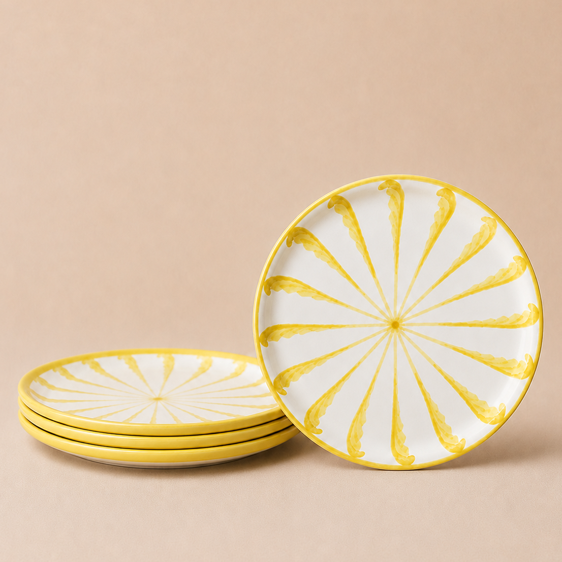 Set of ceramic plates with yellow decorative patterns on a beige background