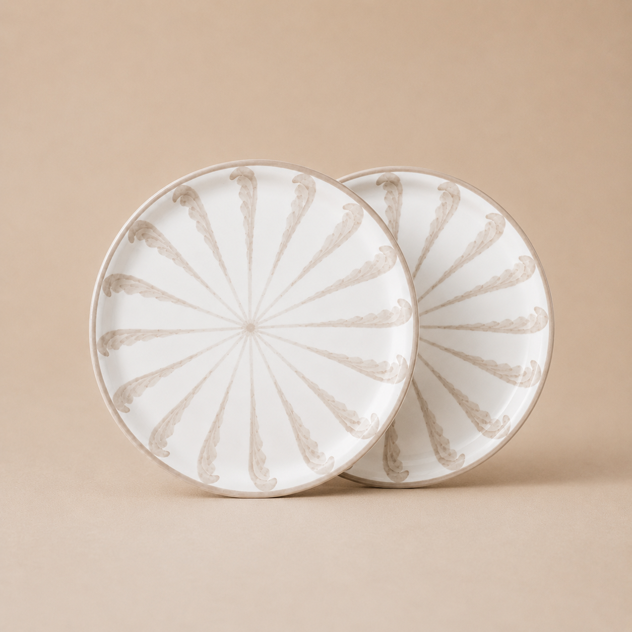 Two ceramic plates with decorative patterns on a beige background
