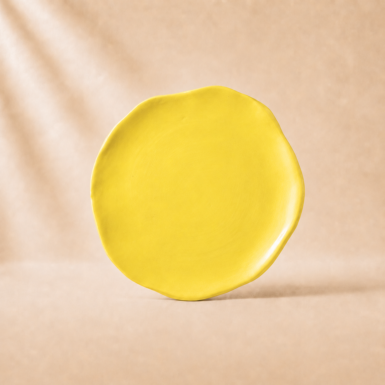 Yellow plate on a beige background