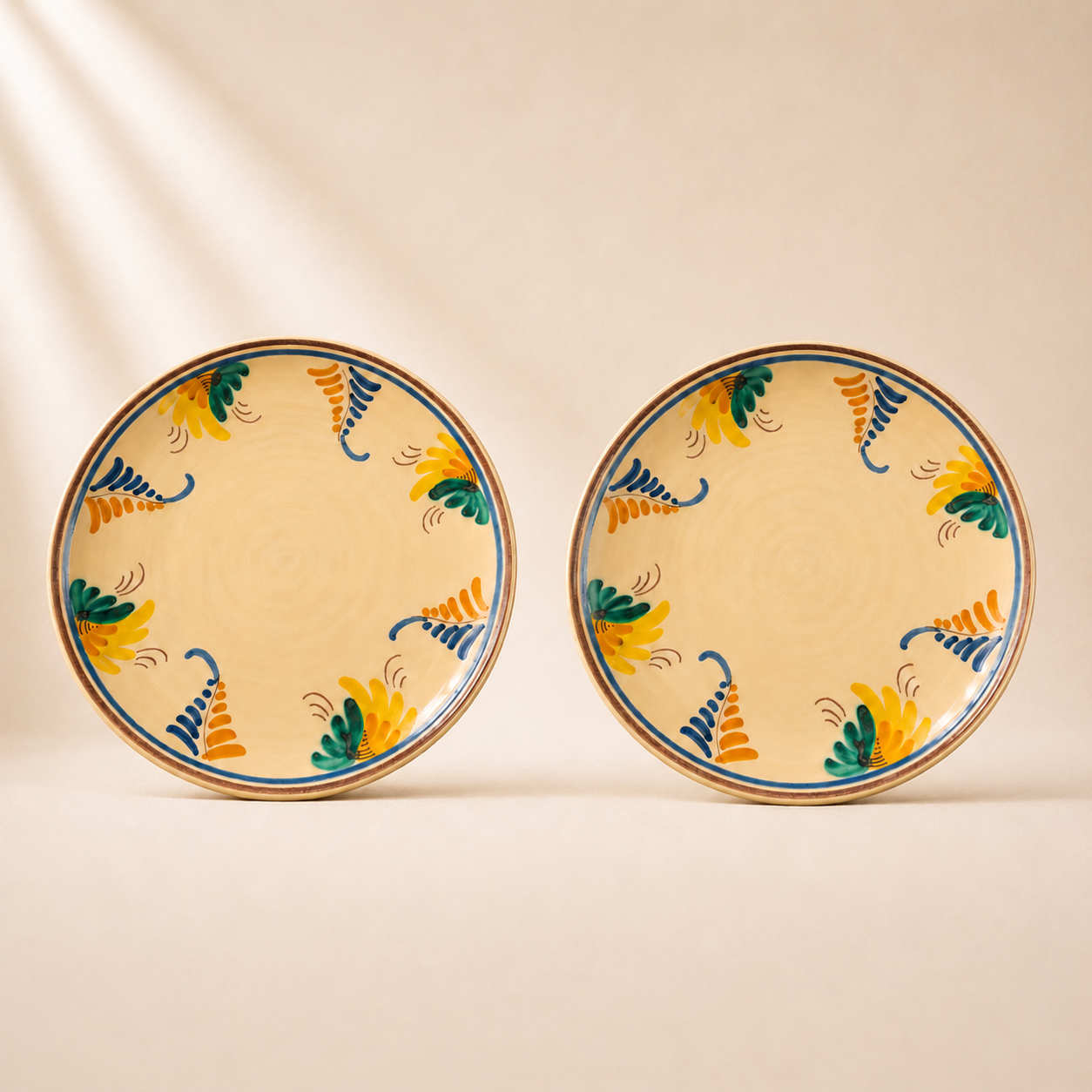 Two ceramic plates with decorative patterns on a beige background