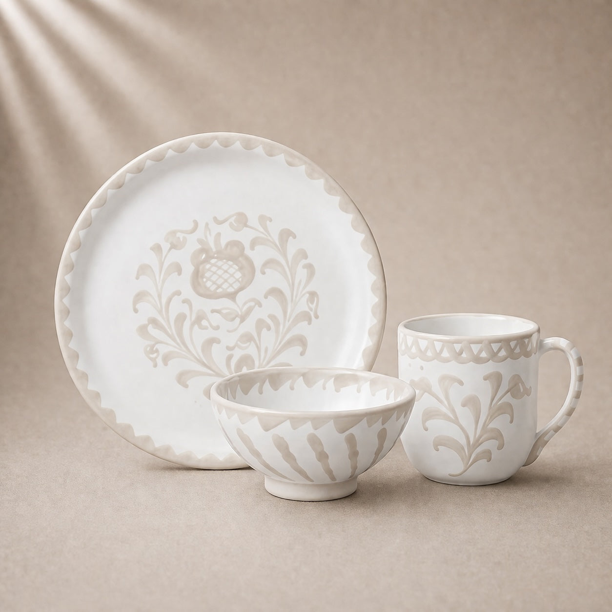 White ceramic dinnerware set with floral patterns on a beige background