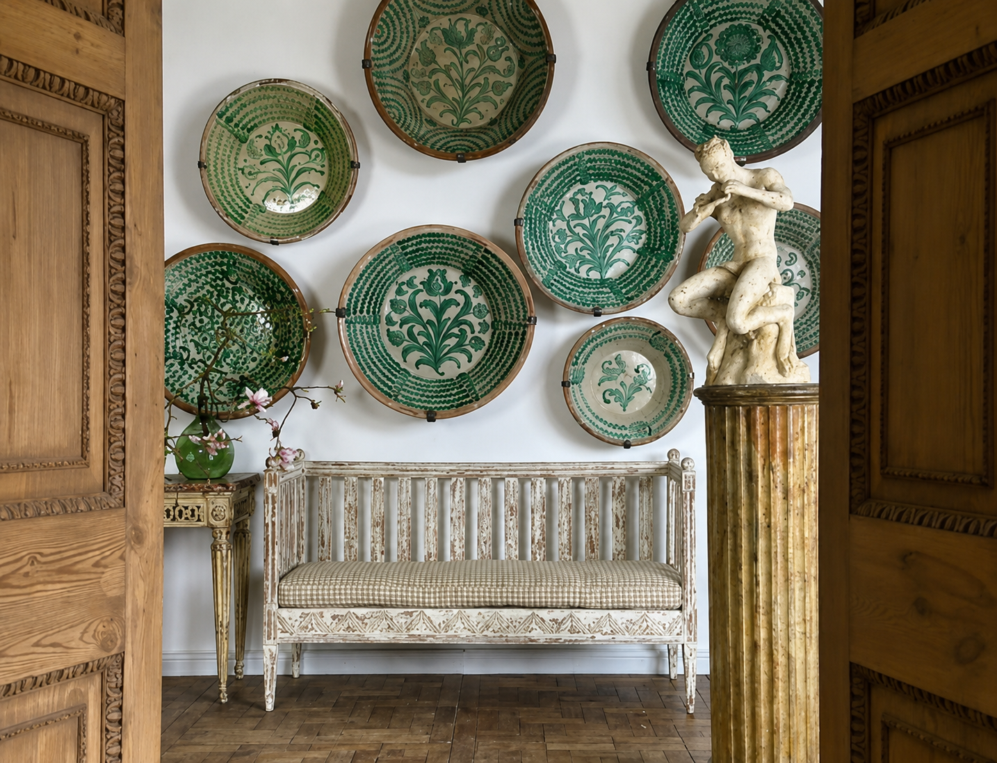 Decorative wall with green ceramic plates and a wooden bench in a room.