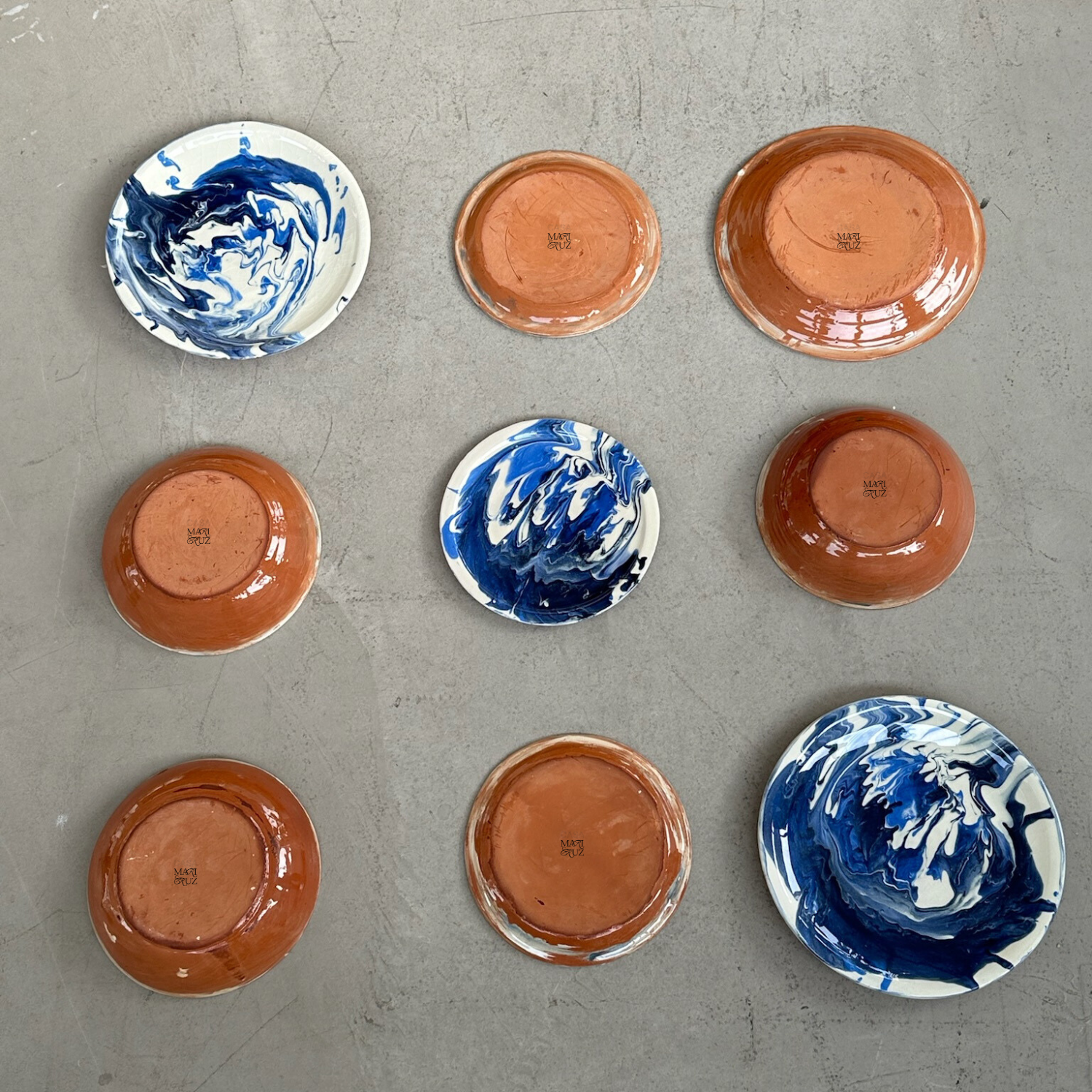Set of ceramic plates with blue and white swirl patterns on a gray surface