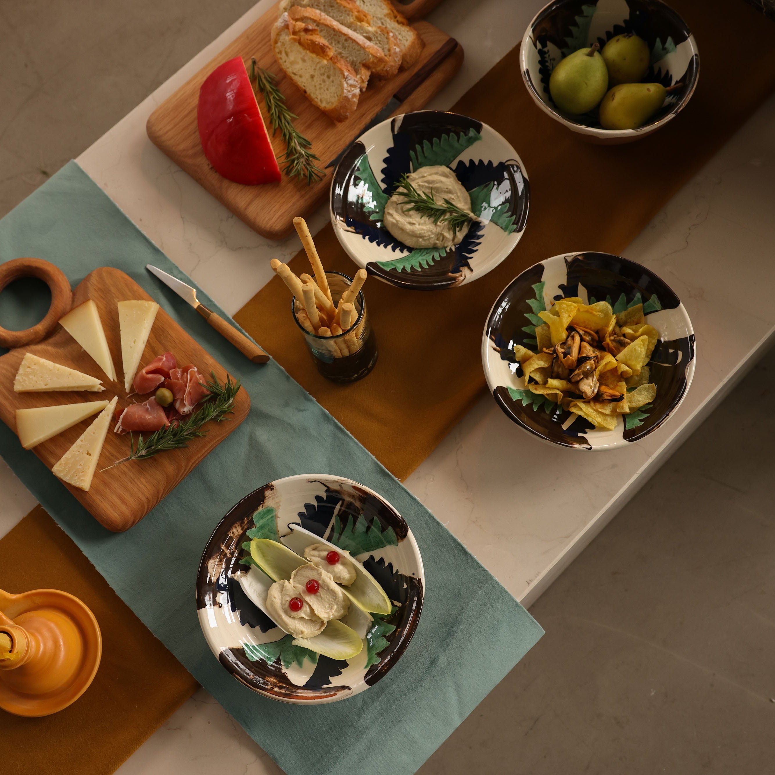Table setting with various dishes of food on a wooden table.