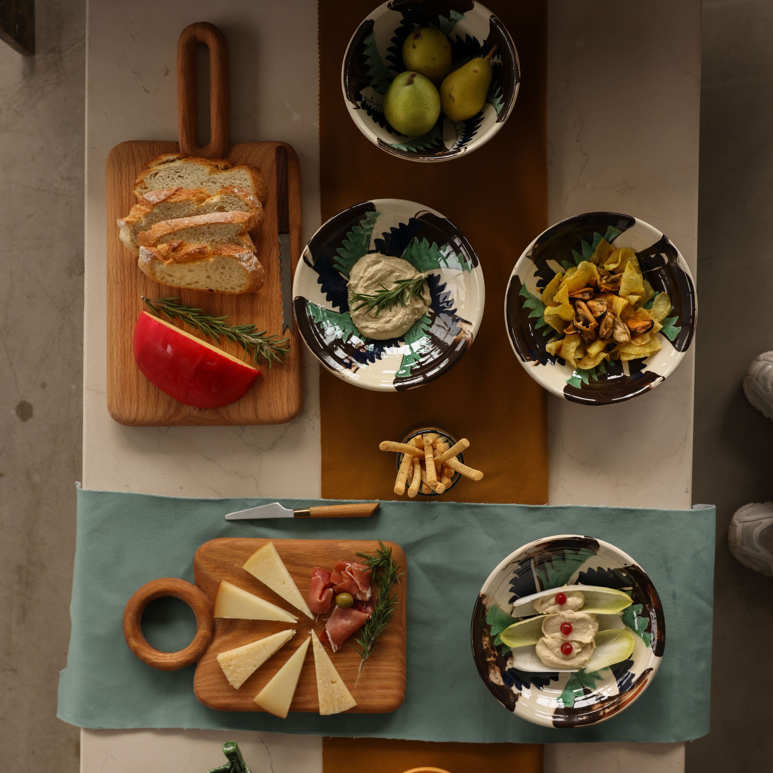 Top-down view of a dining table with various dishes and food items on a checkered tablecloth.