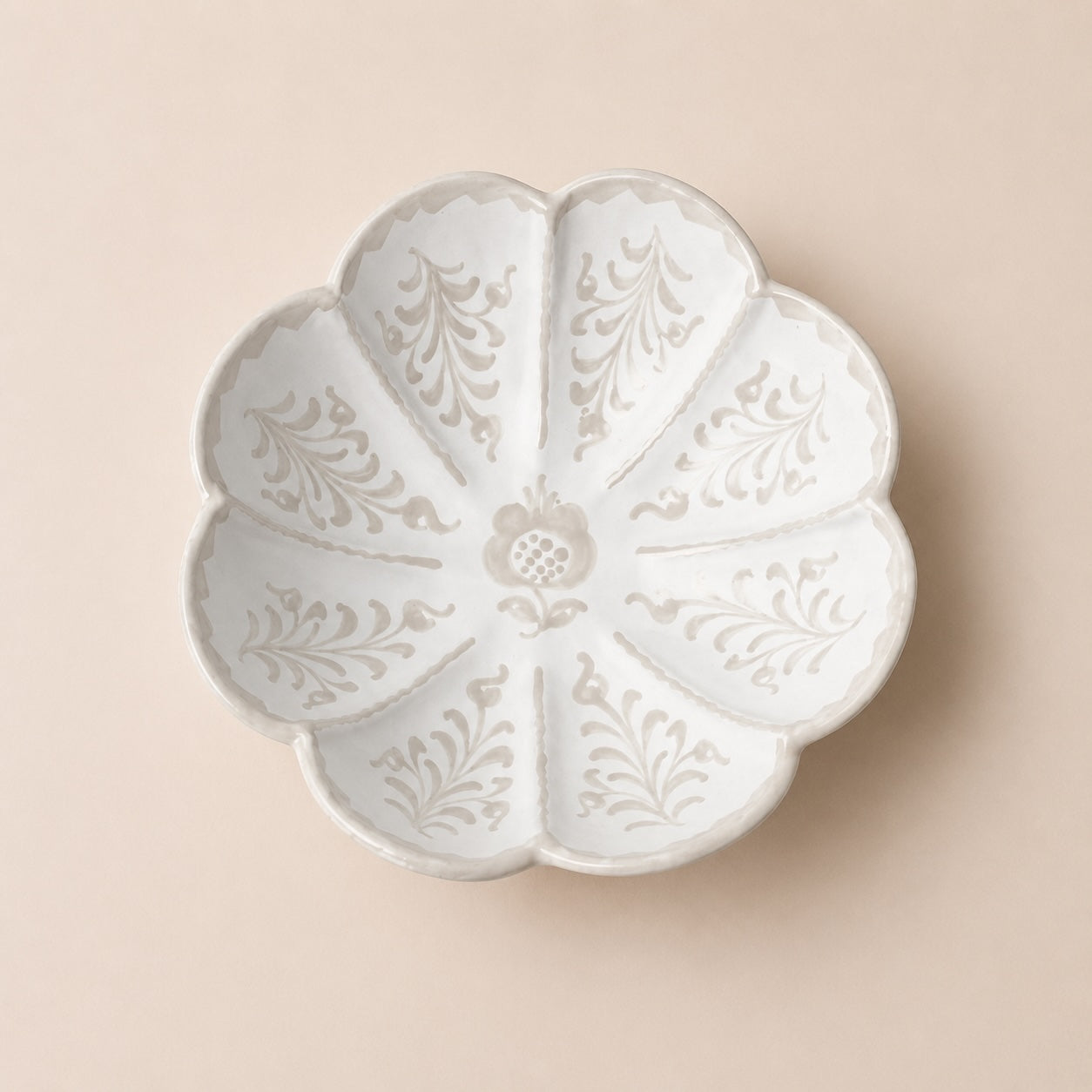 Decorative white ceramic plate with floral patterns on a beige background