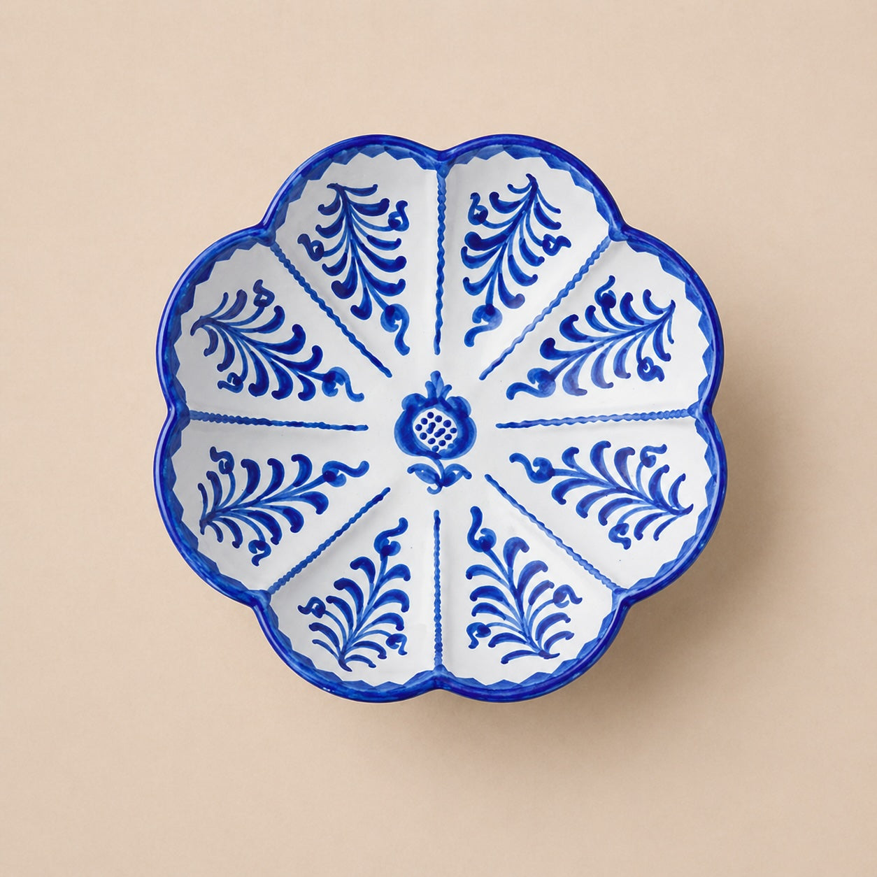 leaf shaped bowl  with blue floral patterns on a beige background