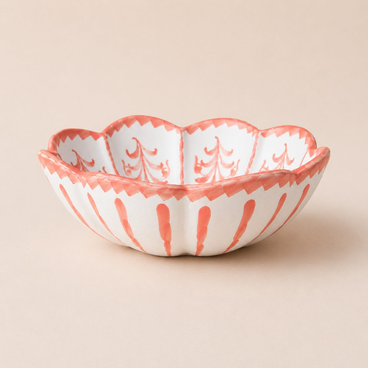Decorative ceramic bowl with coral and white pattern on a beige background