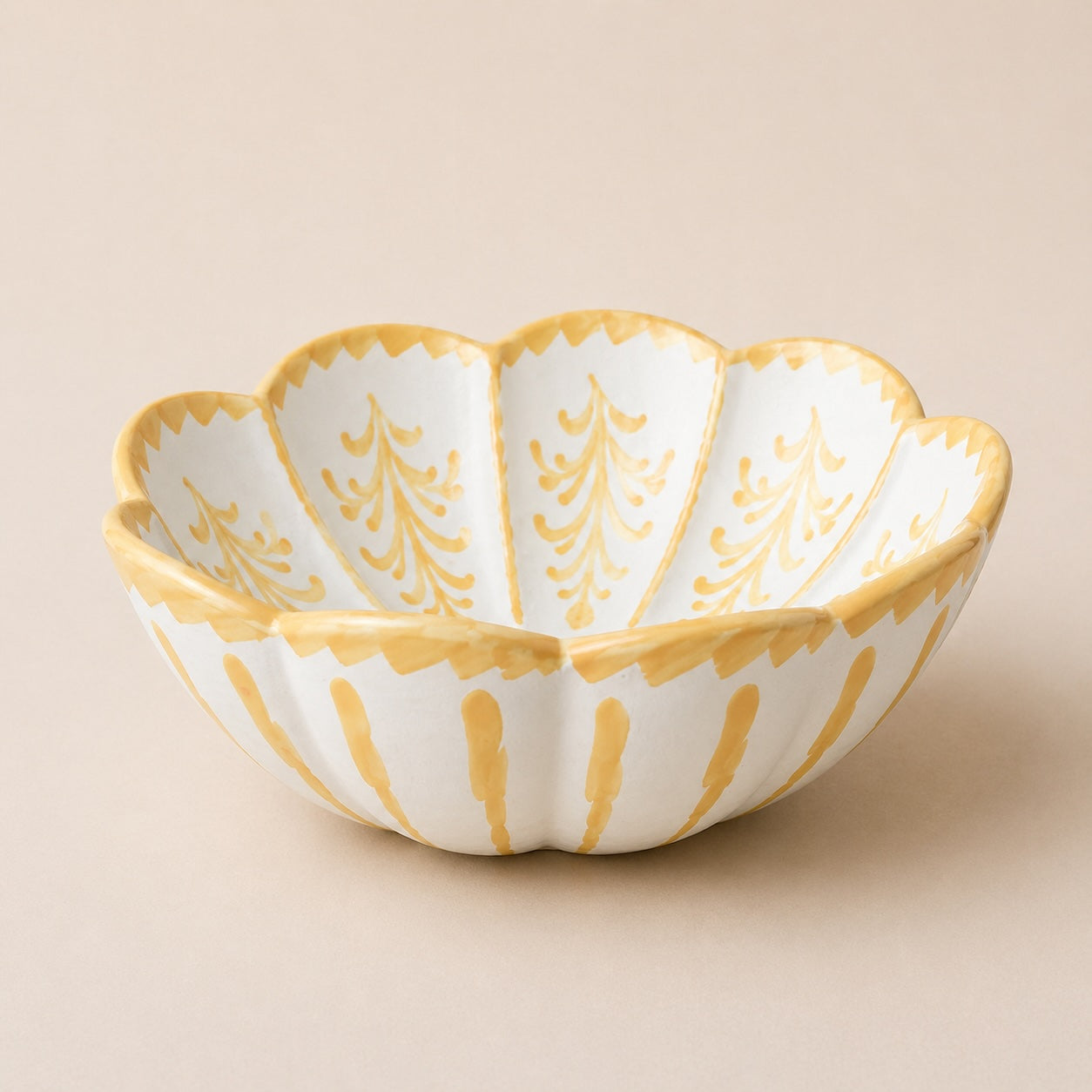 leaf chaped bowl ceramic bowl with gold patterns on a beige background