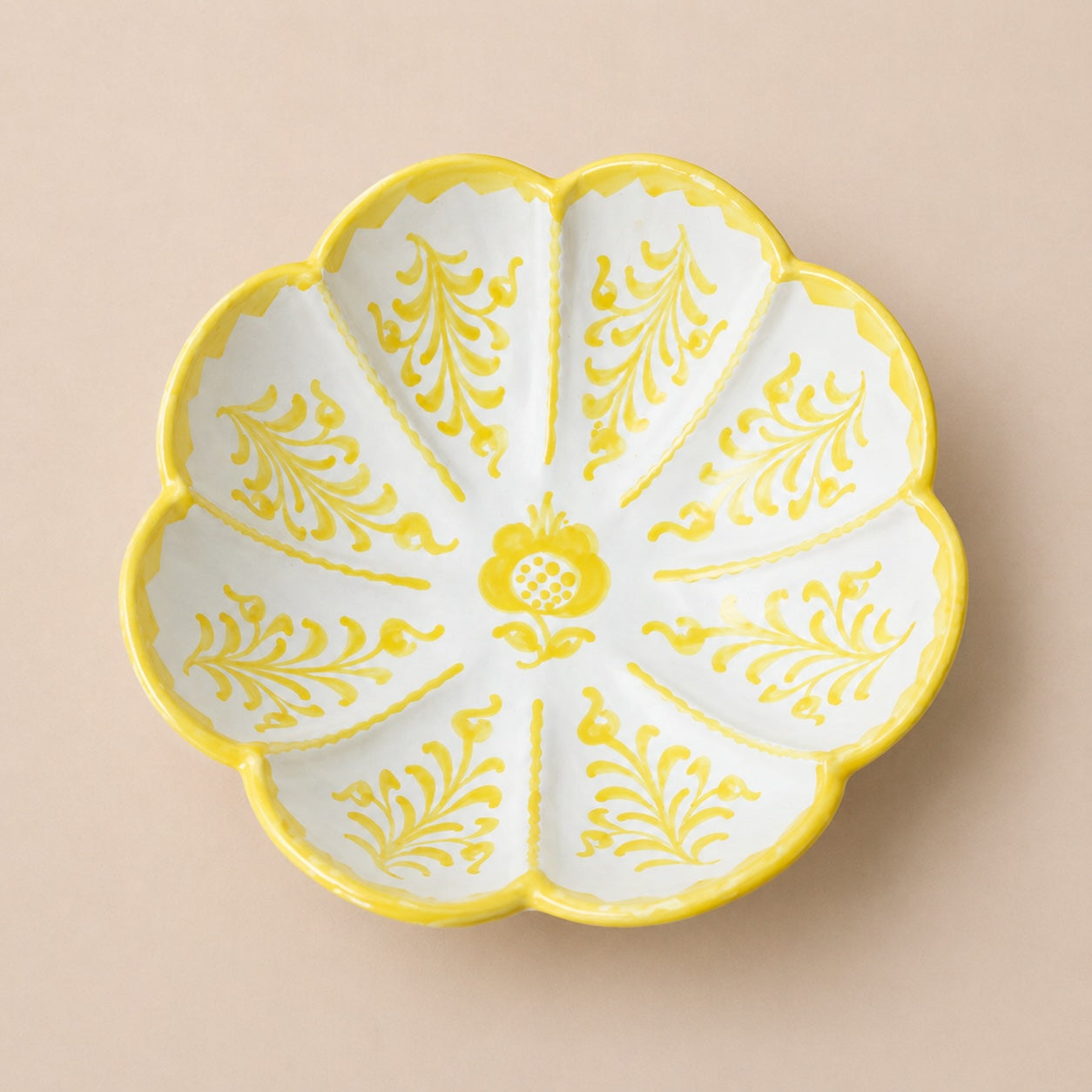 Decorative ceramic plate with yellow floral patterns on a beige background