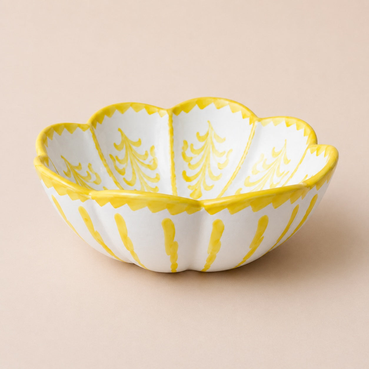 Decorative bowl with yellow and white design on a beige background