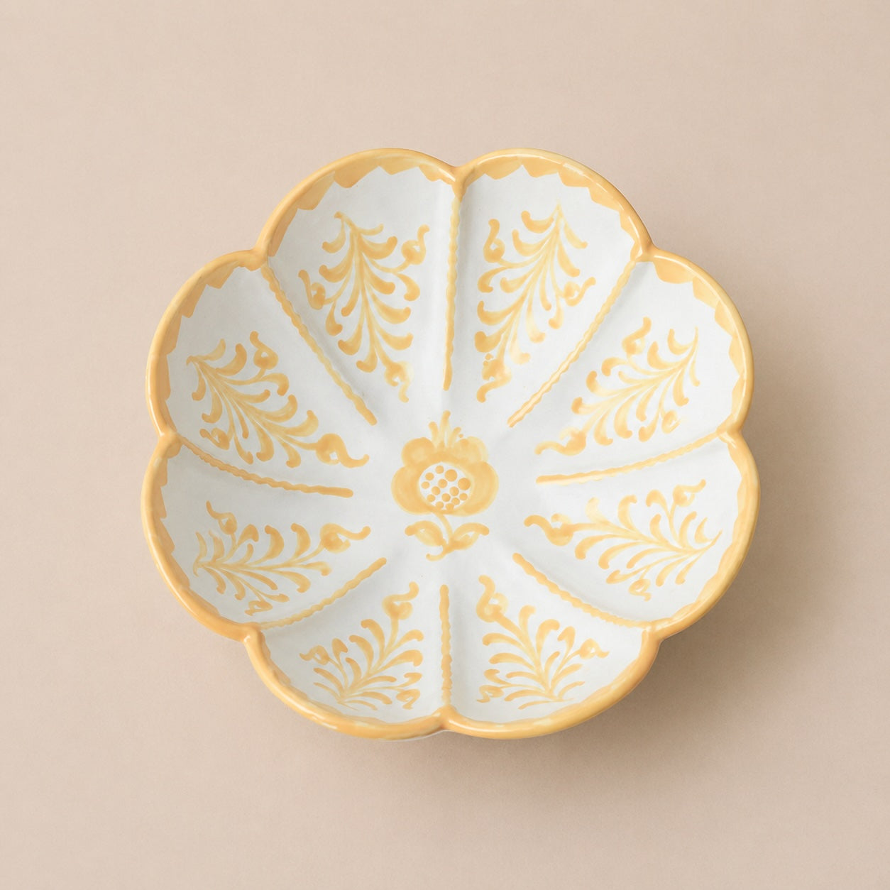 Decorative leaf shaped serving bowl ceramic plate with gold floral patterns on a beige background