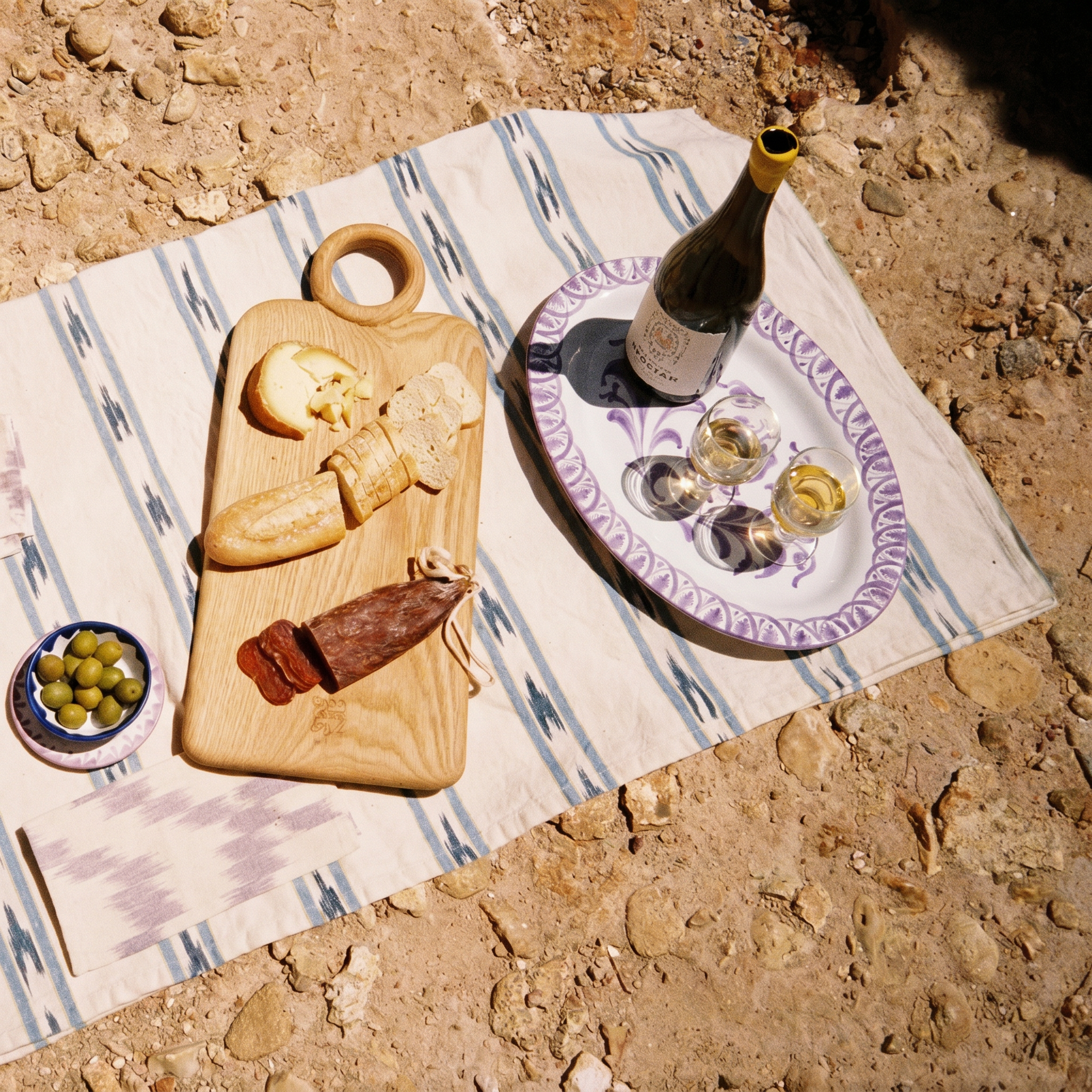 table set on the beach, wooden board and oval plate - lifestyle